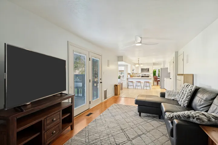 Wood-finish flooring throughout, with ceiling fan, and French doors providing access to an outdoor space