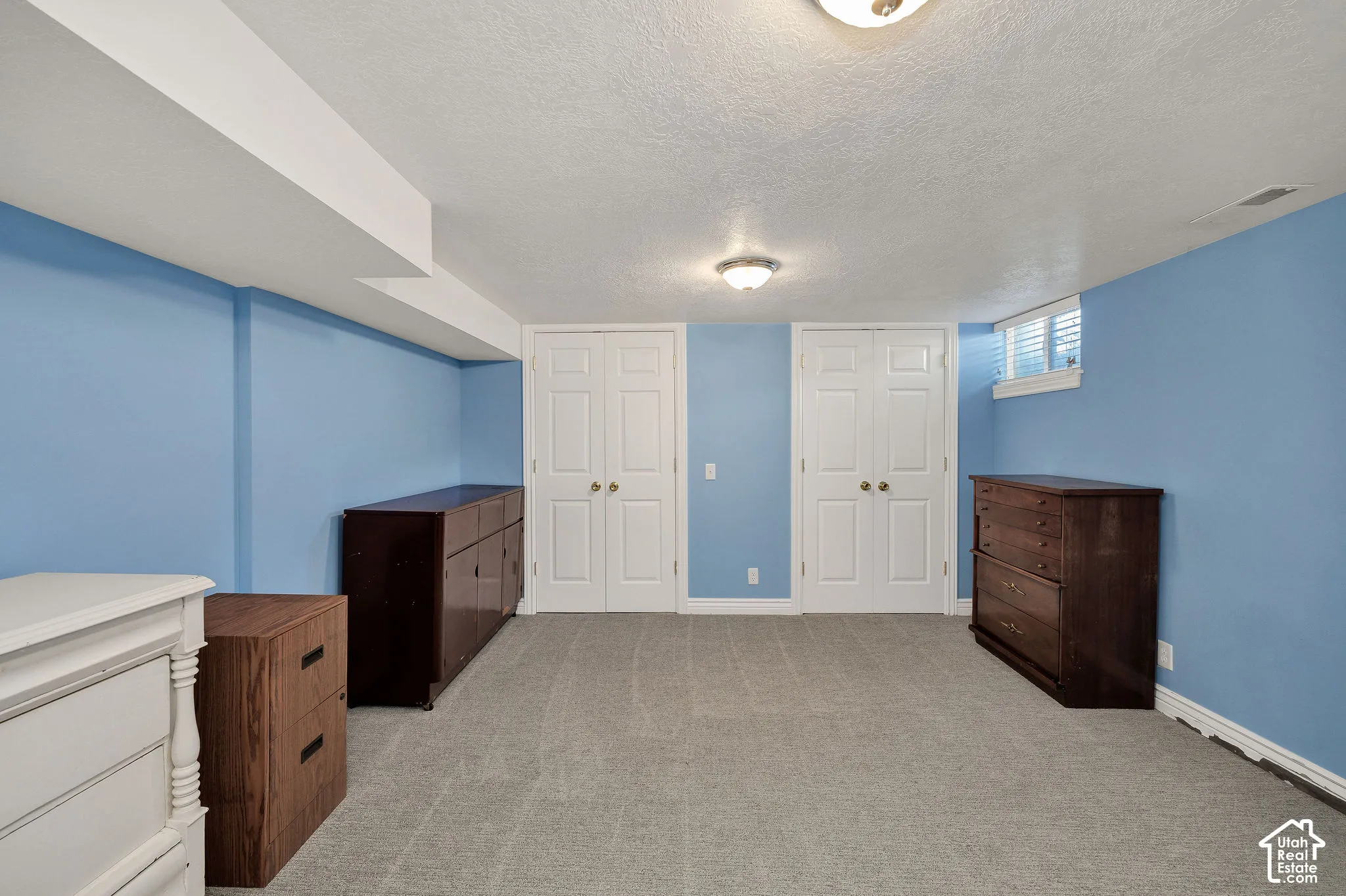Carpeted flooring, recessed window, dual flush-mount ceiling lights, and double bifold doors