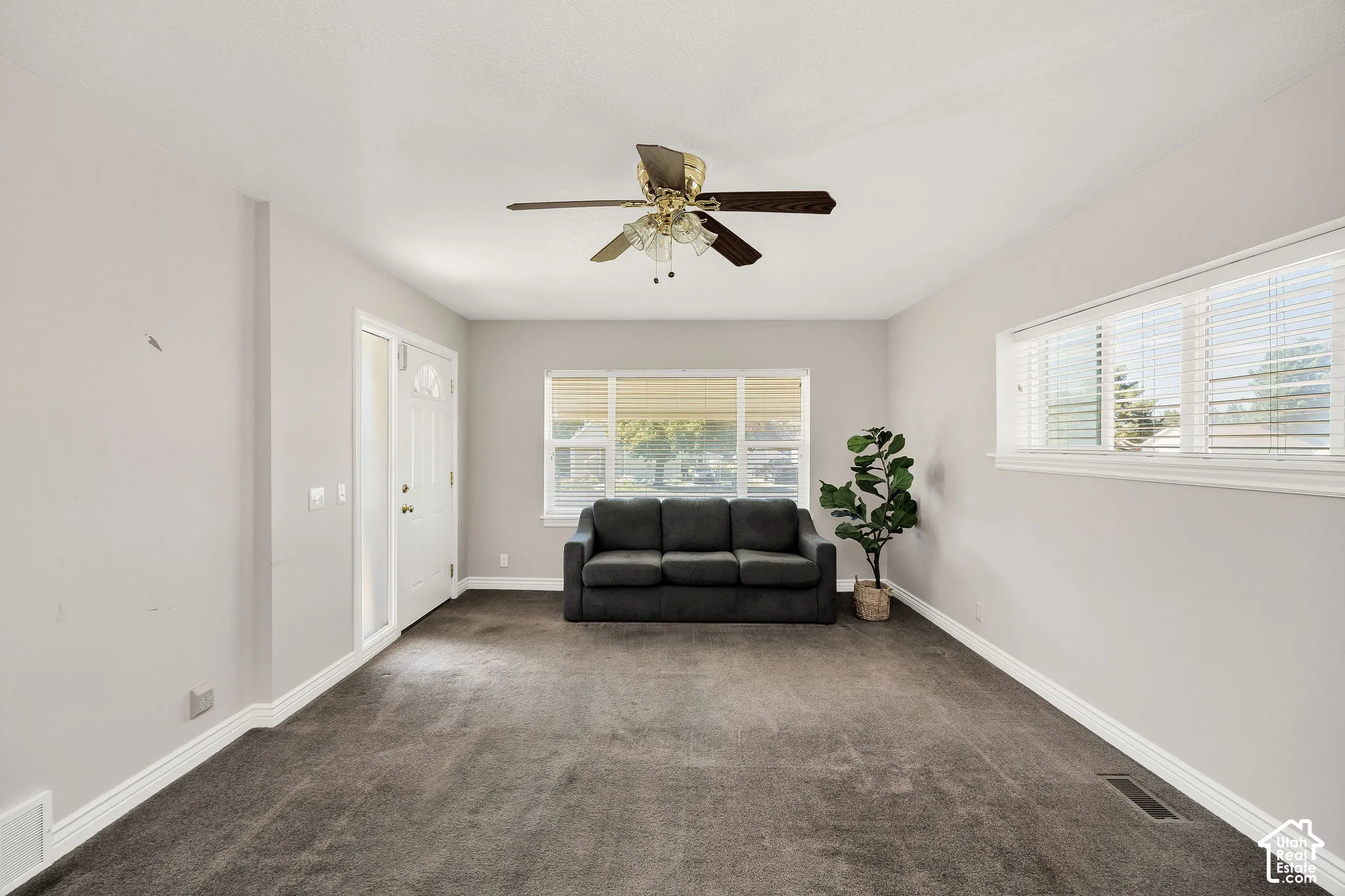 Recessed lighting, ceiling fan, carpet flooring, multiple windows, and a white entry door