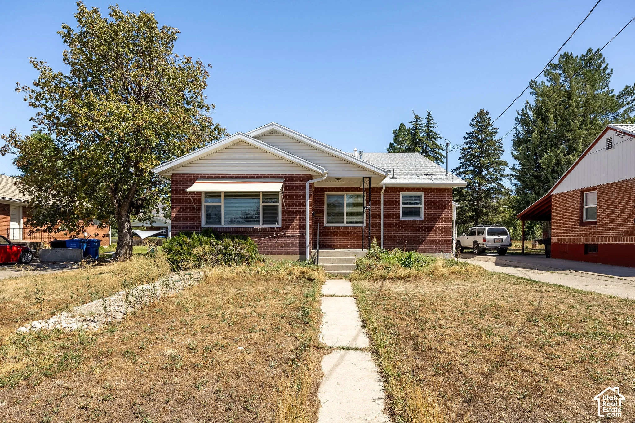 Brick exterior featuring white trim and a gabled roof