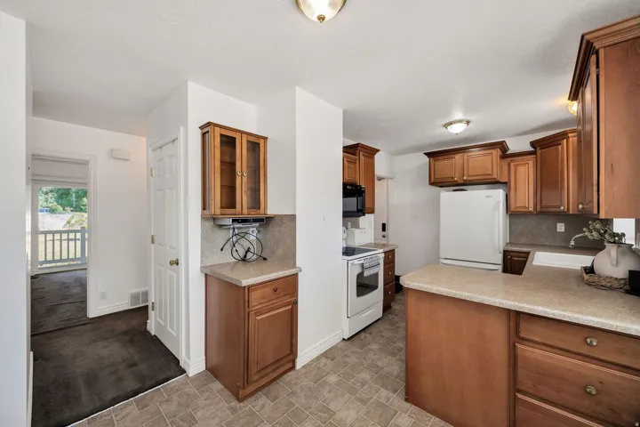 Kitchen featuring wood cabinetry, light-toned countertops, and tile flooring