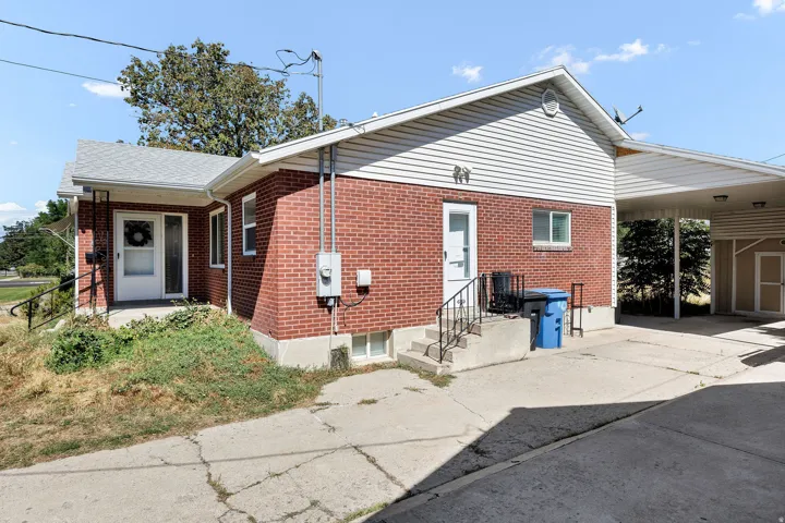 Brick exterior with white siding accents and a covered carport
