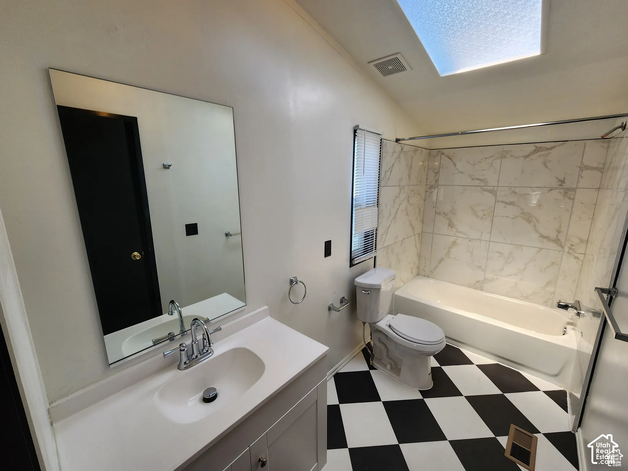 White vanity with integrated sink, chrome faucet, and rectangular mirror