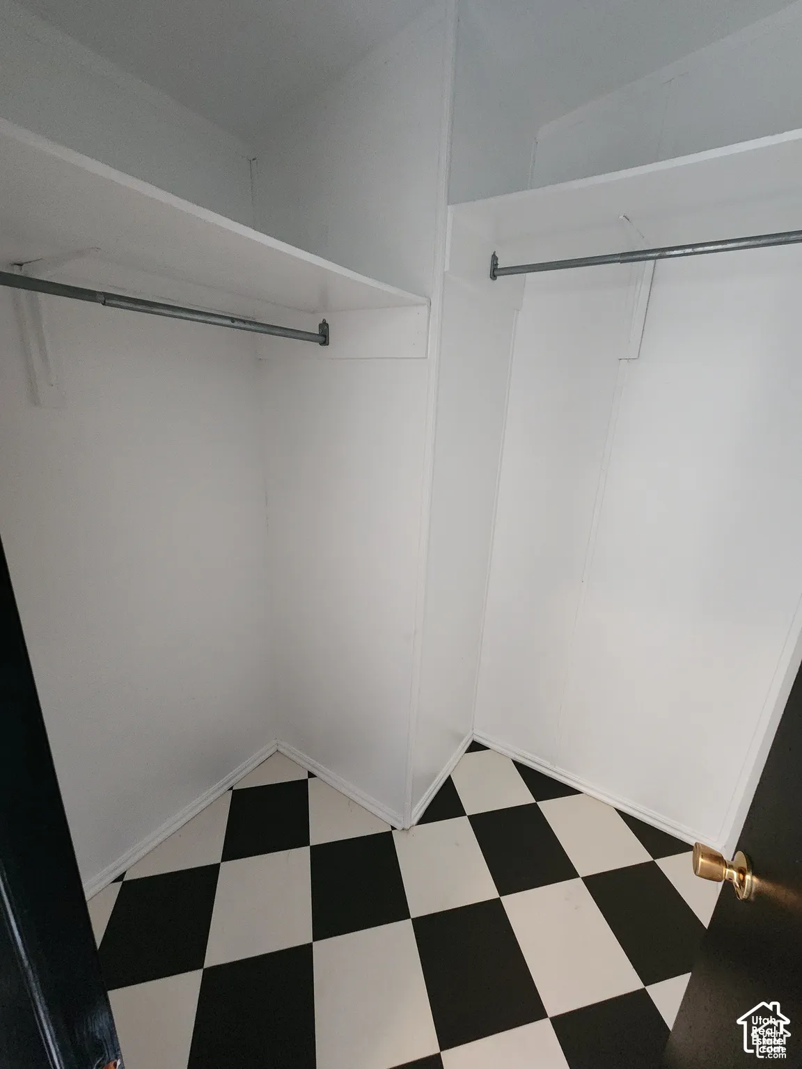 Built-in shelving, hanging rods, and checkerboard floor tiling