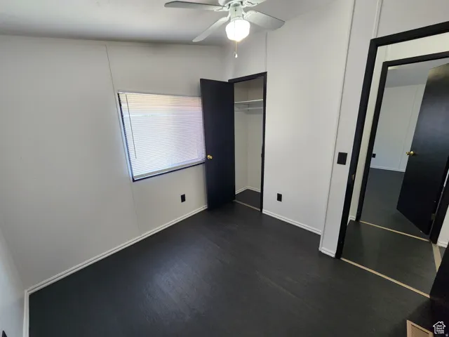 Dark-toned flooring, white walls, and a window with blinds