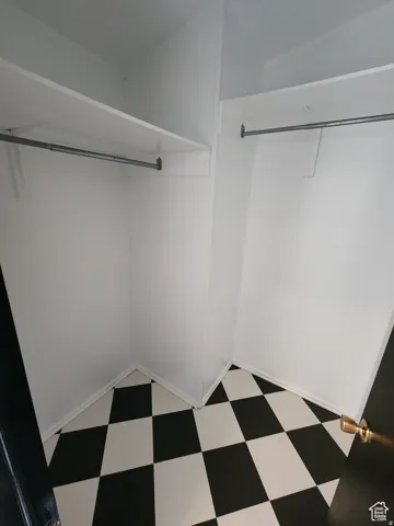 Built-in shelving, hanging rods, and checkerboard floor tiling