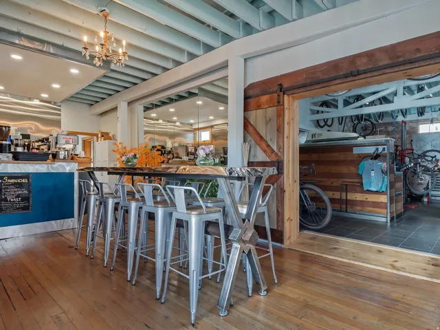 Exposed ceiling beams, wood-finish flooring, and a barn door