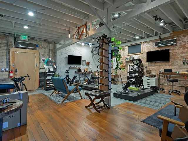 Exposed brick wall accents, wood-finish flooring, exposed ceiling beams, recessed lighting, and track lighting fixtures