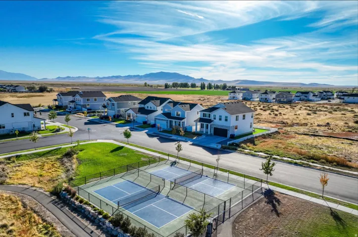 Community setting featuring newly constructed residences, paved streets, and multiple sports courts