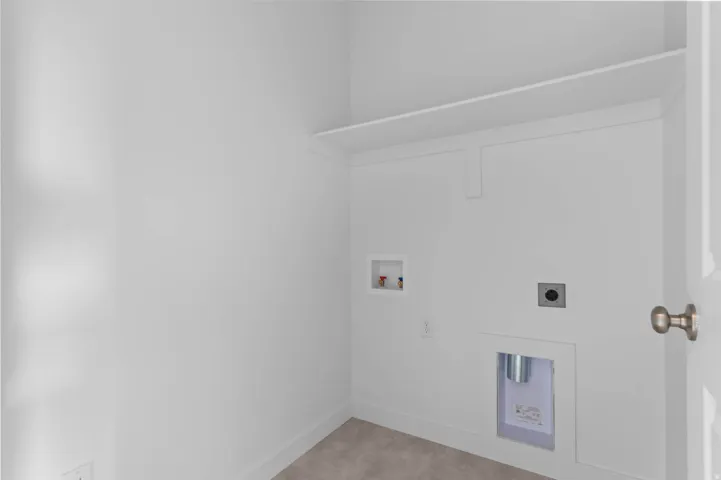 Laundry area with a built-in shelf, appliance hookups, and a neutral wall finish