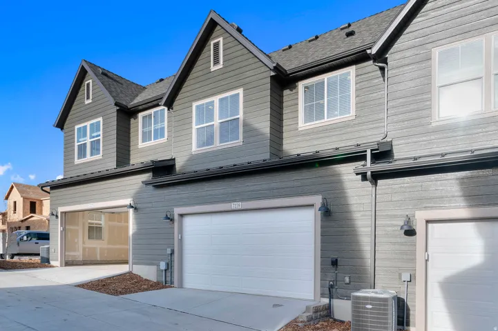 Multi-level exterior with siding, dormer windows, and a shingled roof