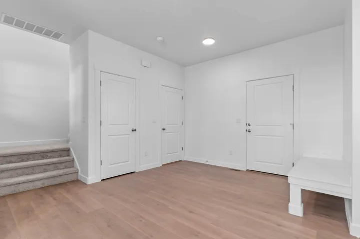 Wood-finish flooring, recessed lighting, and white paneled doors