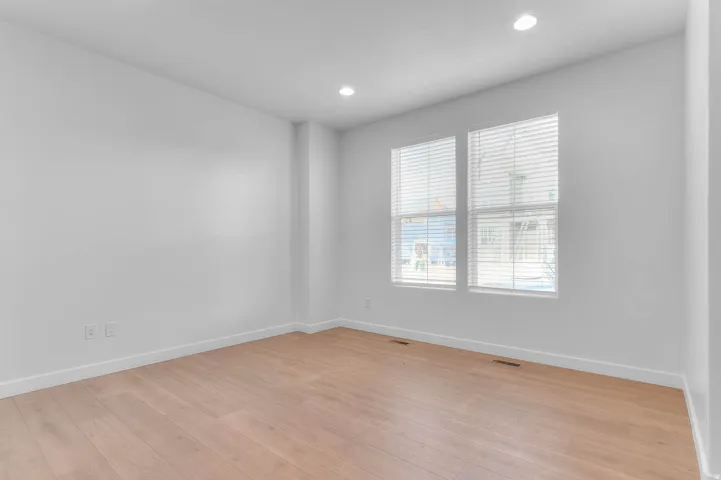 Recessed lighting illuminates the light wood-finish flooring