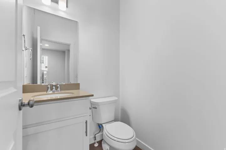 White vanity with shaker-style door, integrated sink, and light-colored countertop