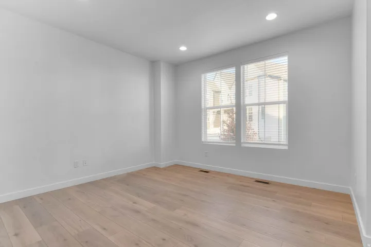 Light wood-finish flooring with crisp white walls and recessed ceiling lighting