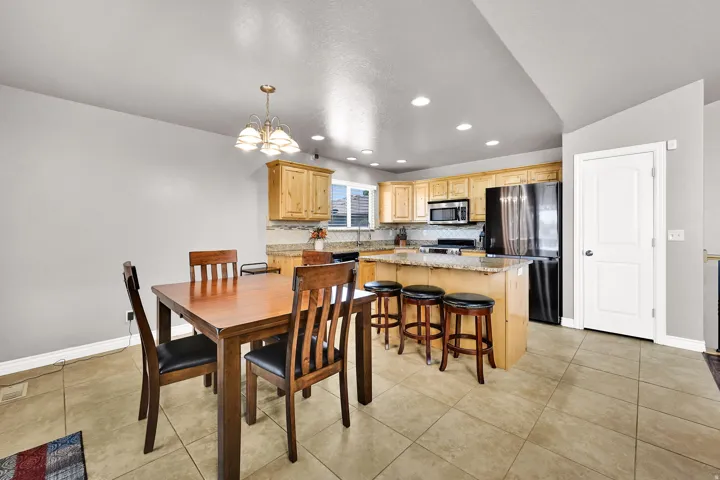 Kitchen featuring wood cabinetry, granite countertops, tile backsplash, and stainless steel appliances