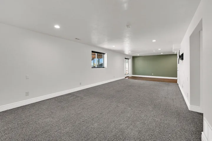 Spacious room featuring recessed lighting, a window, and a door leading to the exterior