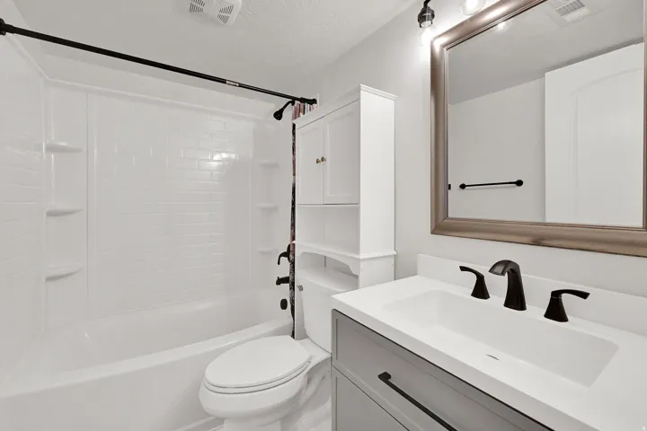 White shower/tub combination with subway tile-patterned surround