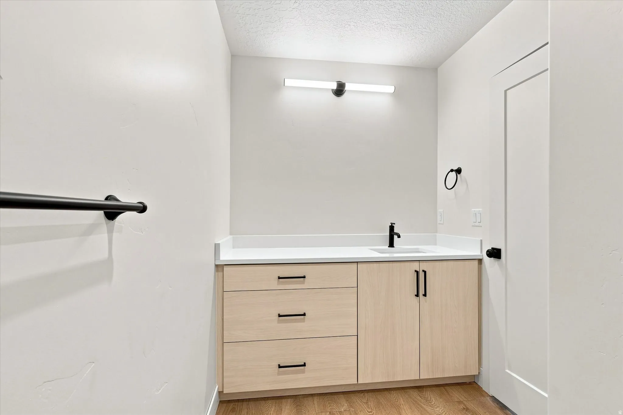 Light wood-finish vanity with ample storage and a white countertop