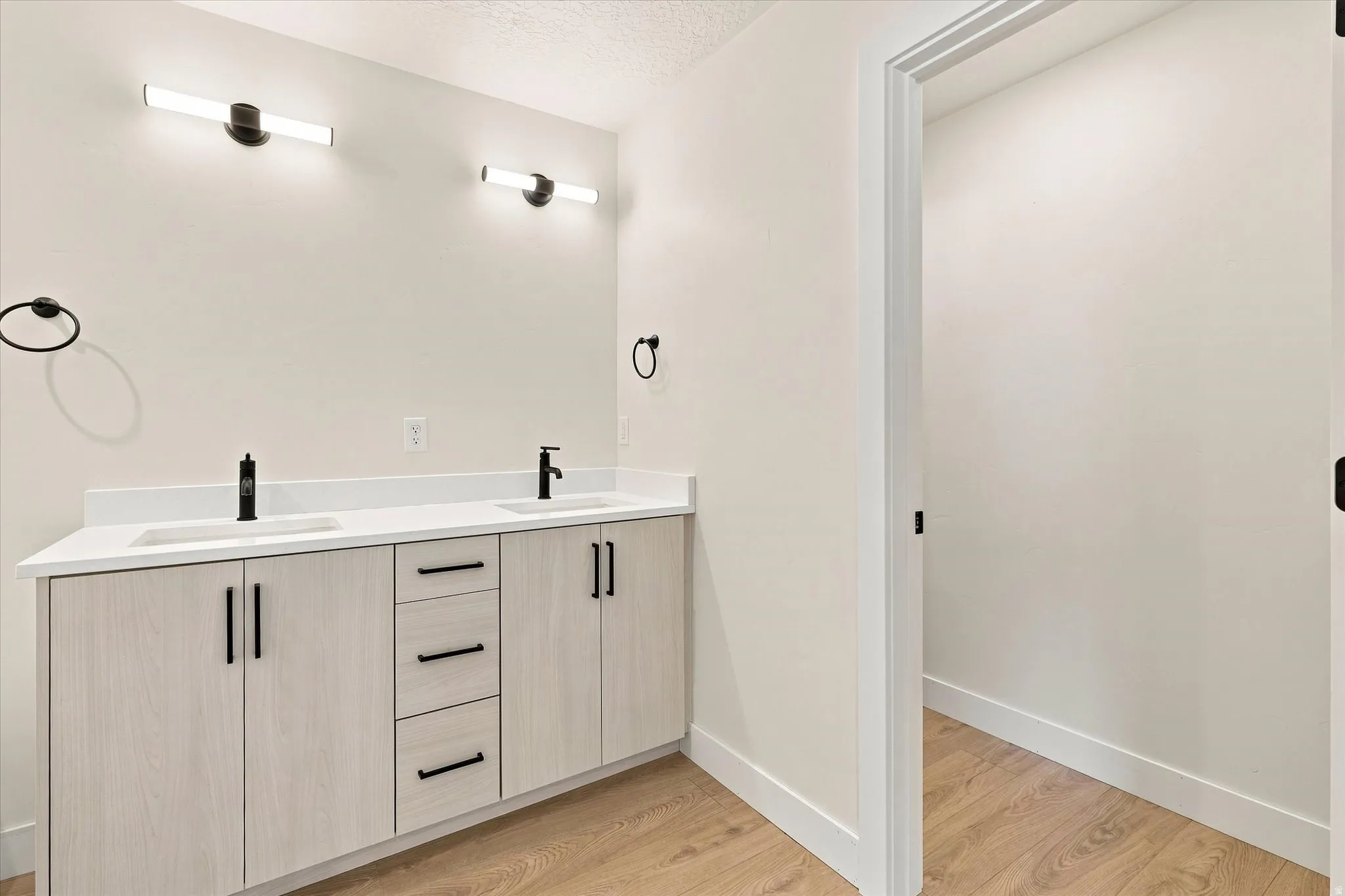 Dual vanity with a white countertop, undermount sinks, and matte black fixtures