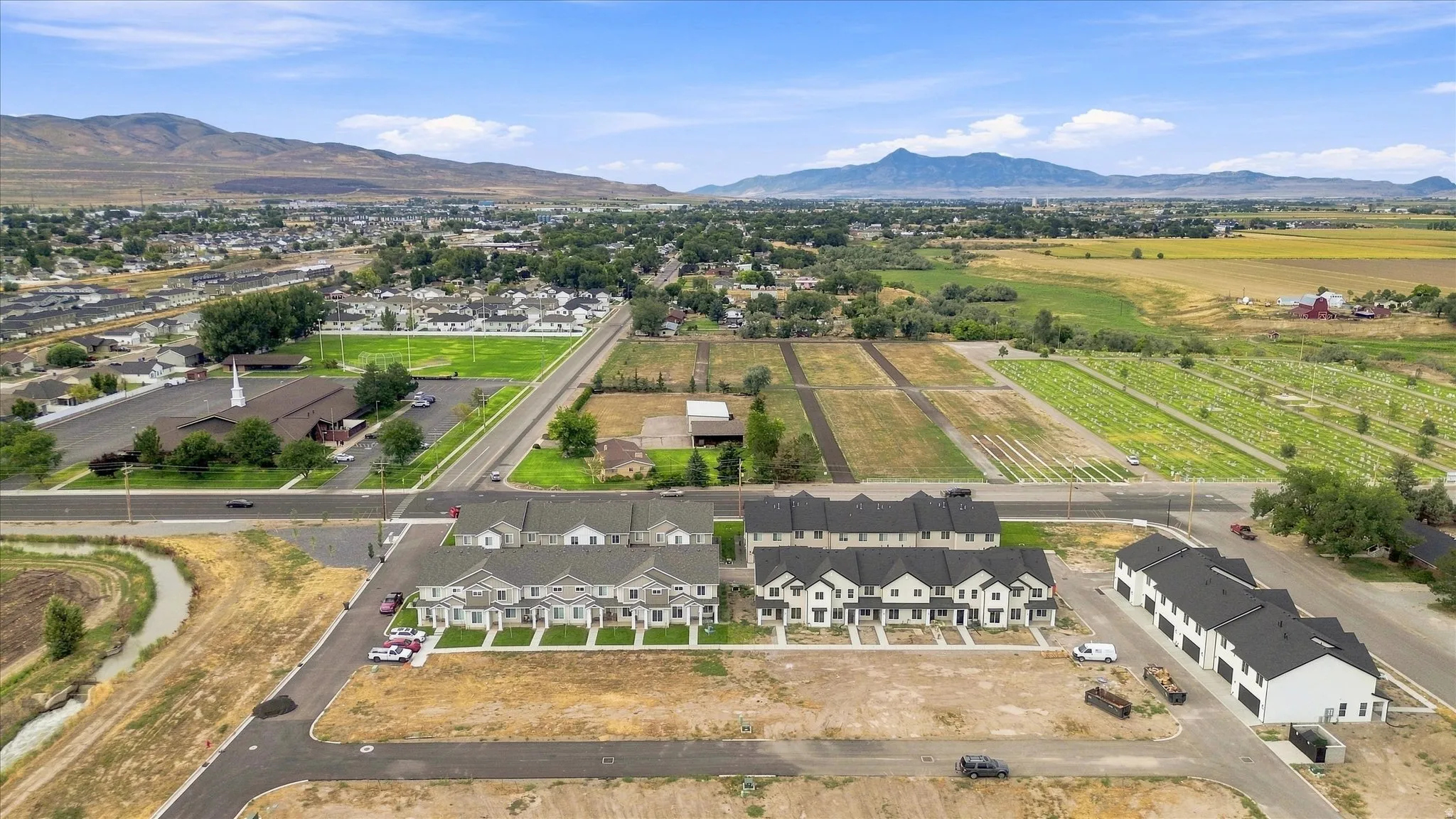 Aerial perspective showcasing new construction townhomes with surrounding residential areas and distant mountains