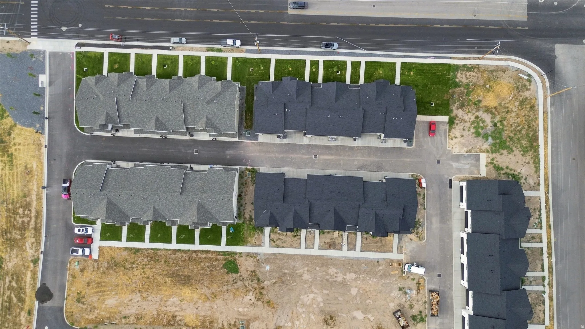 Modern residential development featuring multiple buildings, paved roadways, and landscaped green spaces