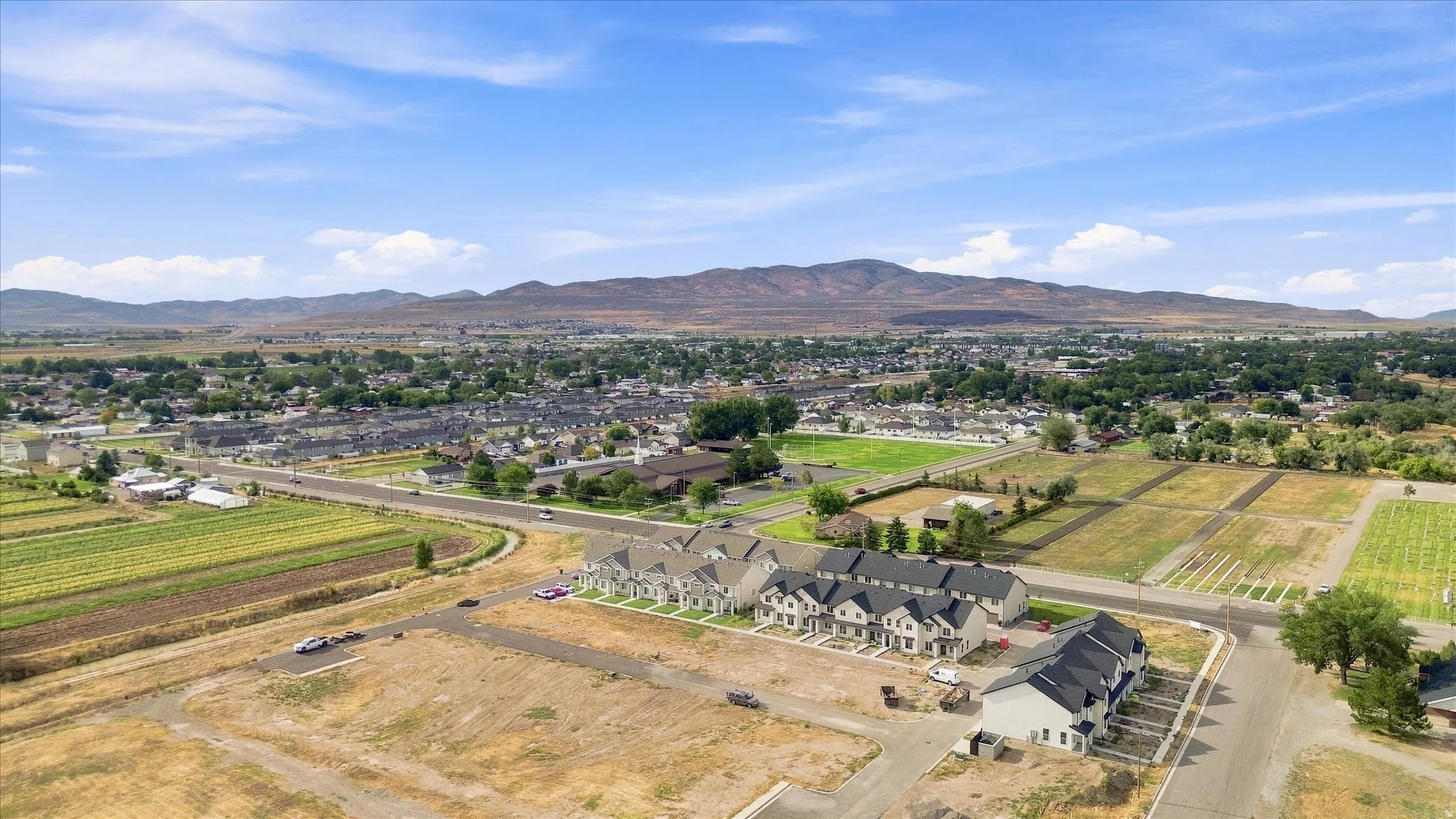 Townhome community featuring multi-story units, dark shingle roofing, and light-colored siding