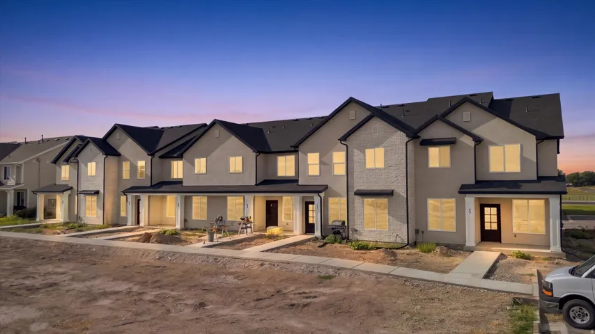 Modern townhome exteriors featuring multi-pane windows, covered entryways, and dark shingle roofing