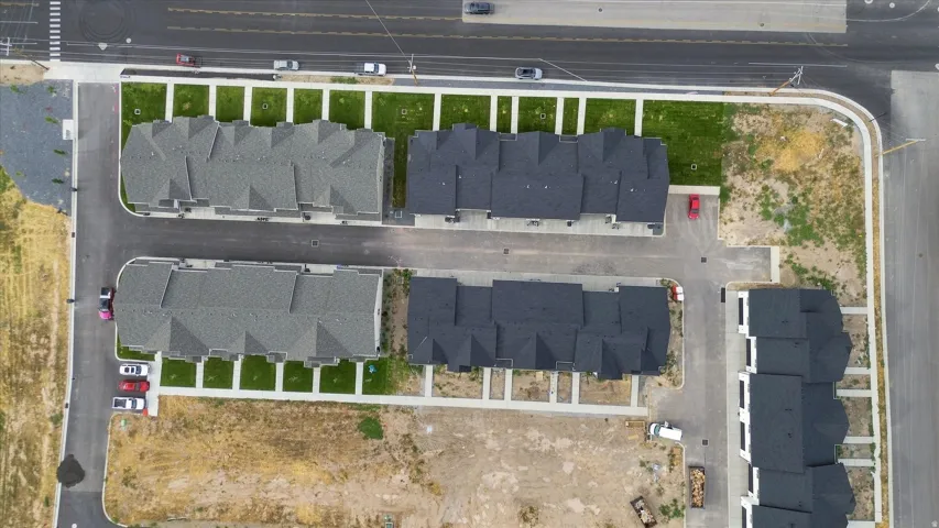 Modern residential development featuring multiple buildings, paved roadways, and landscaped green spaces