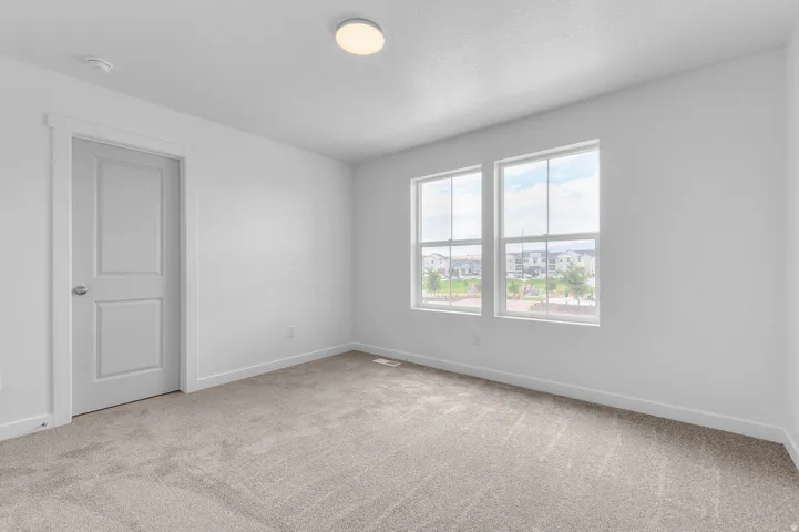 Recessed lighting, light-colored carpet flooring, white walls, and two large windows