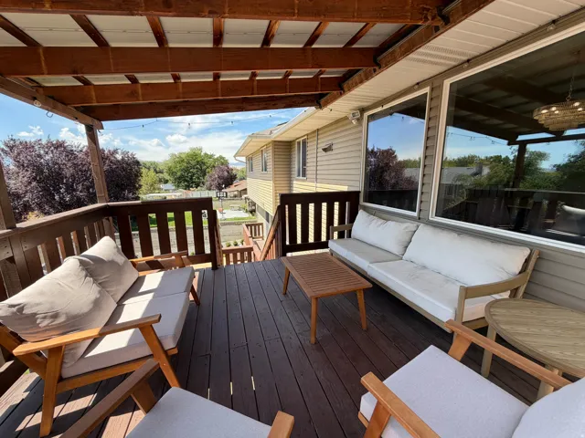 Expansive outdoor deck featuring wood-finish flooring, a full-length wood railing, and a slatted wood ceiling