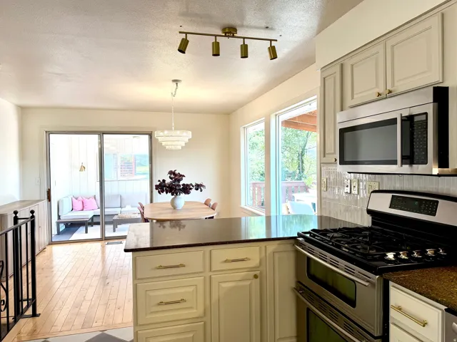 Kitchen with light-toned cabinetry, stainless steel appliances, and dark countertops