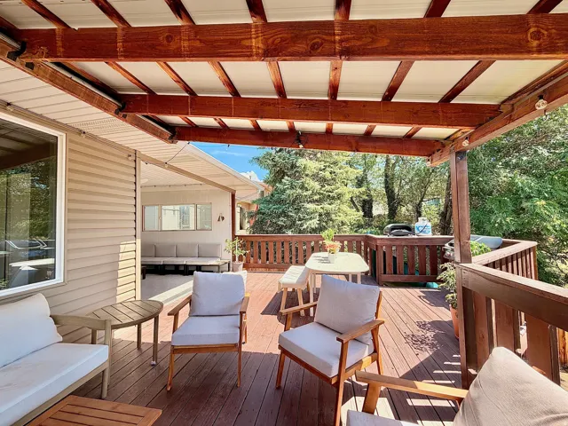 Expansive wood deck with a built-in pergola featuring a solid roof