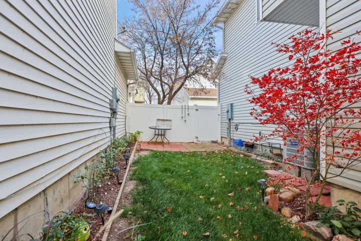 Fenced yard with a grassy area and mature tree