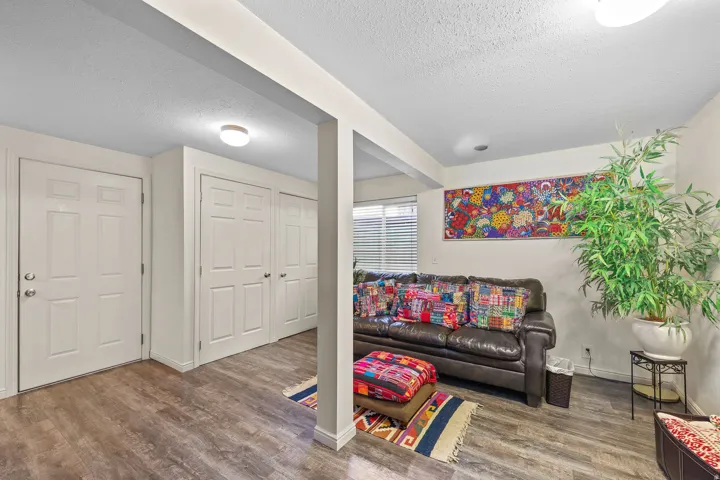 Wood-finish flooring throughout, featuring a white paneled door, two sets of white bifold closet doors, and recessed lighting
