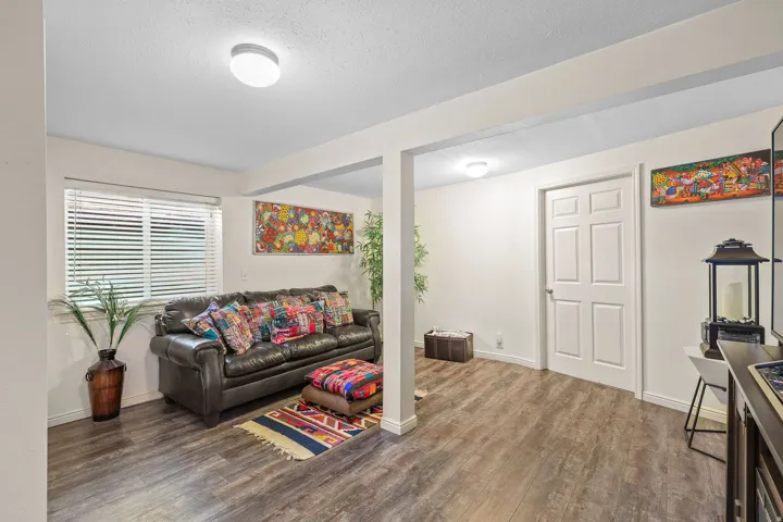Recessed lighting, wood-finish flooring, white paneled door, and a window with blinds