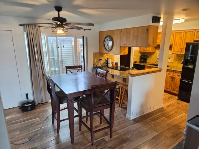 Wood-finish flooring throughout, with a ceiling fan featuring an integrated light fixture