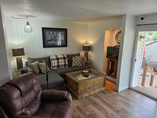 Wood-finish flooring throughout, recessed wall niche, and sliding glass door with exterior deck access