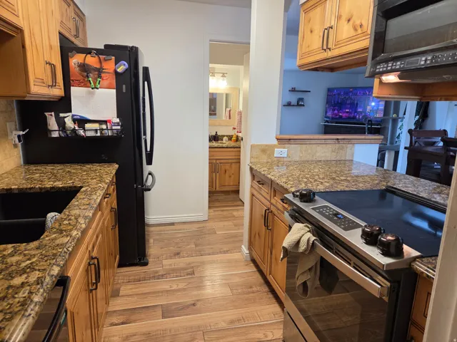 Wood-finish flooring throughout, complemented by light wood cabinetry with dark hardware