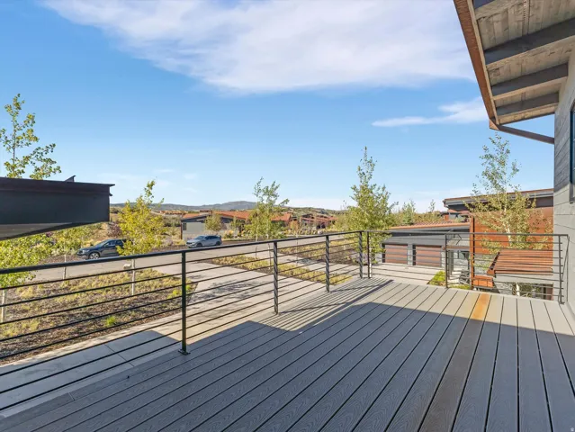 Expansive outdoor deck featuring composite decking, black metal railings, and natural surroundings