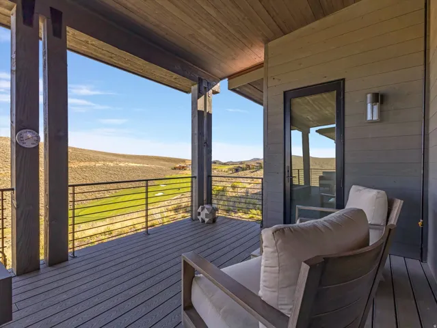 Covered outdoor deck with wood-finish ceiling, horizontal wood siding, and metal railing