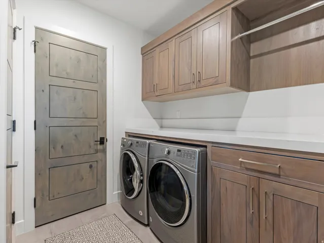 Wood-finish cabinetry, light-toned countertop, and built-in hanging rod