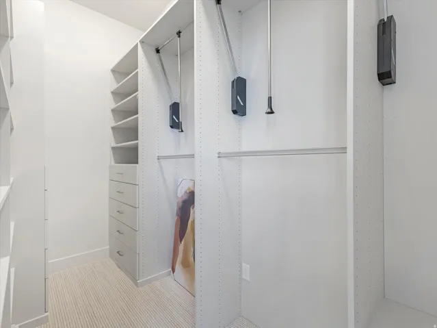 Built-in closet system featuring shelving, drawers, and adjustable hanging rods