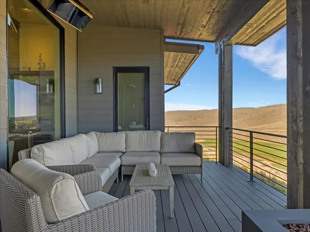 Spacious outdoor deck featuring composite decking, wood-plank ceiling, and a modern horizontal railing
