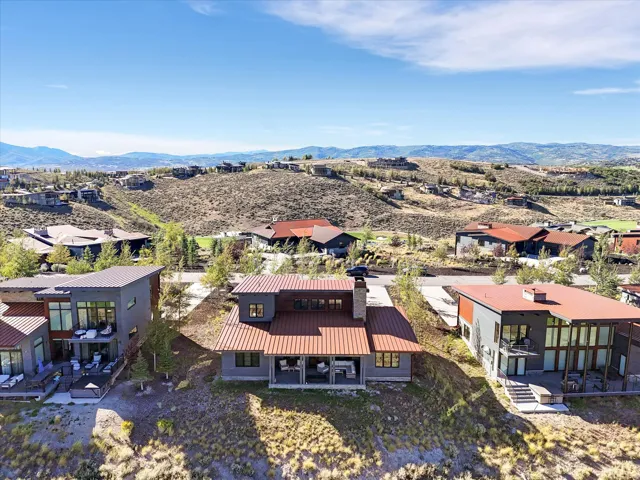 Modern architecture with multiple outdoor patio spaces, expansive windows, and a metal roof