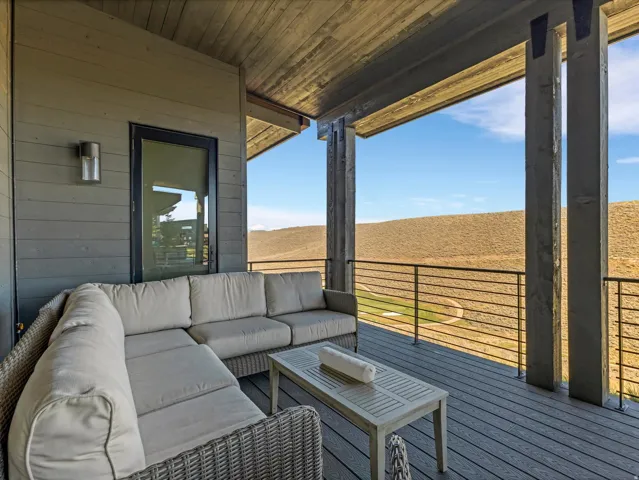 Covered outdoor deck with composite decking, exposed wood ceiling, and metal railing