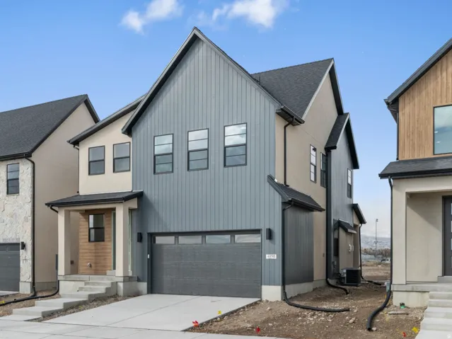 Contemporary exterior with vertical panel siding, a covered front entry, and an integrated garage