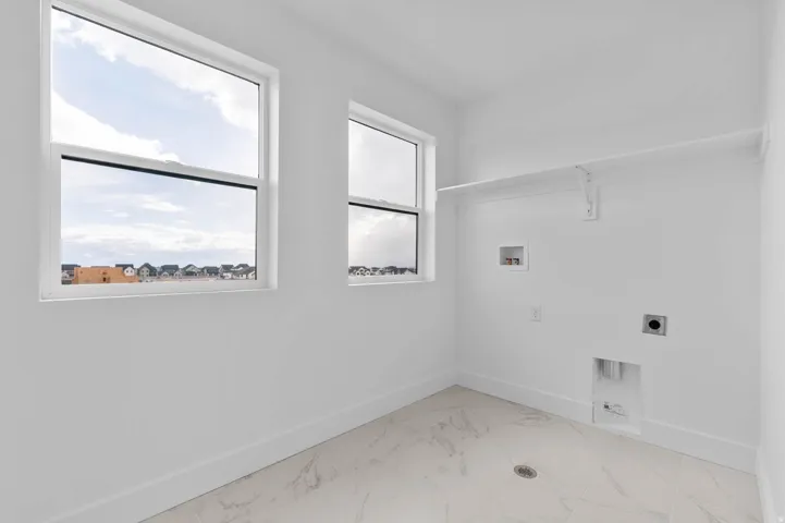 White walls with a single built-in shelf, two windows, and white tile flooring