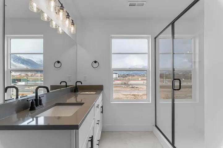 Double vanity with integrated sinks, quartz countertop, and matte black fixtures