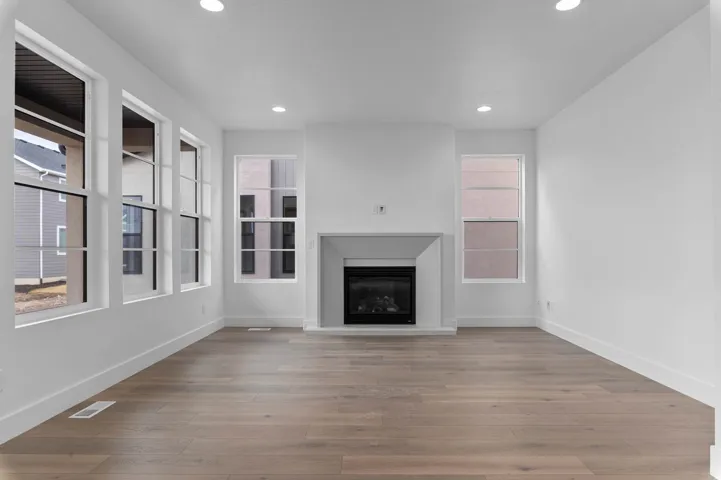 Wood-finish flooring with a modern fireplace featuring a dark firebox